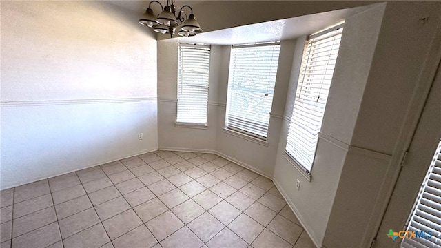 unfurnished dining area with a chandelier and light tile patterned floors