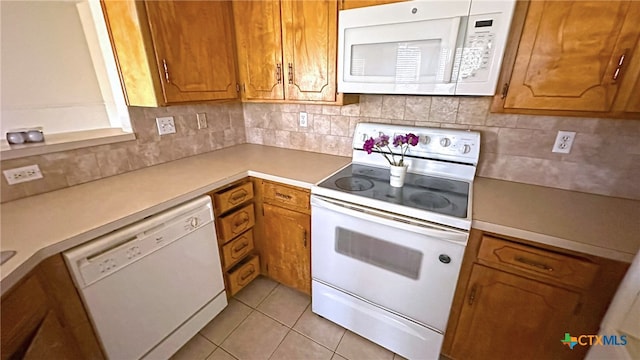 kitchen with white appliances, light tile patterned floors, and decorative backsplash