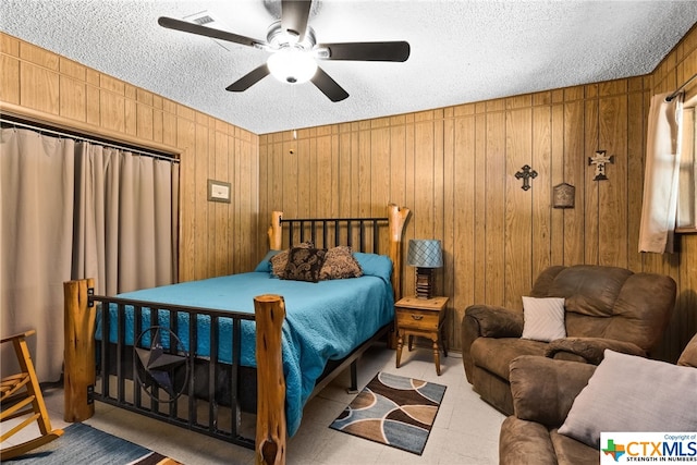 210 N 8th St, Lometa, TX 76853 - bedroom with a textured ceiling, wood walls, and ceiling fan