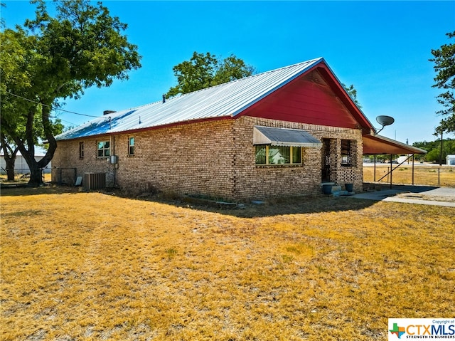 210 N 8th St, Lometa, TX 76853 - view of property exterior with an attached carport, brick siding, and metal roof