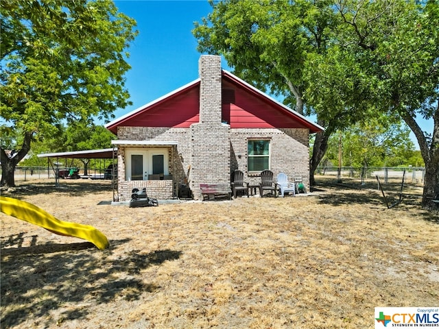 210 N 8th St, Lometa, TX 76853 - rear view of house with a chimney, french doors, and brick siding