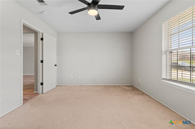 spare room with baseboards, a ceiling fan, visible vents, and carpet floors