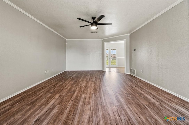 spare room featuring a ceiling fan, a textured ceiling, visible vents, ornamental molding, and dark wood-style floors