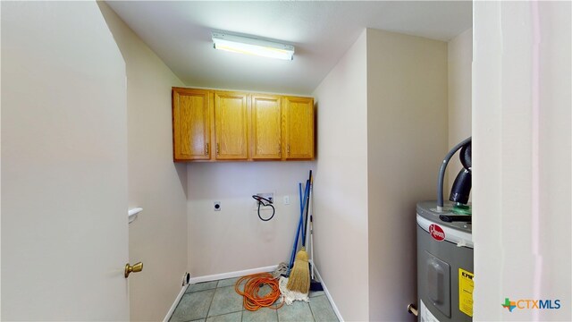 901 E Sarah St, Cuero, TX 77954 - laundry area with cabinet space, hookup for an electric dryer, water heater, baseboards, and tile patterned floors
