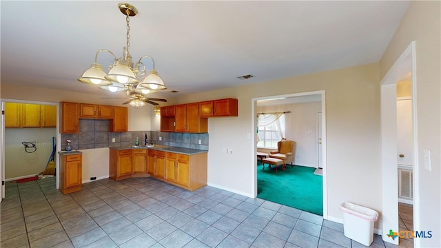 901 E Sarah St, Cuero, TX 77954 - kitchen featuring a chandelier, a sink, decorative backsplash, ceiling fan, and pendant lighting