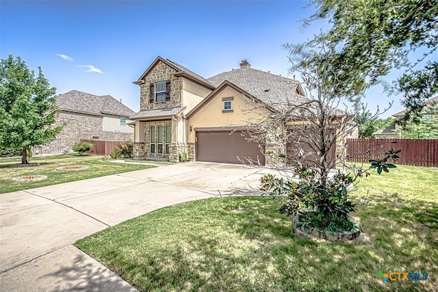 view of front of property with fence, concrete driveway, a front yard, stucco siding, and stone siding