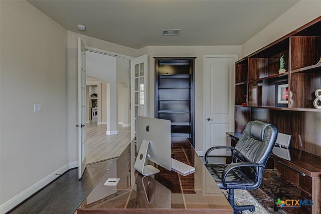 office space with visible vents, baseboards, and wood finished floors