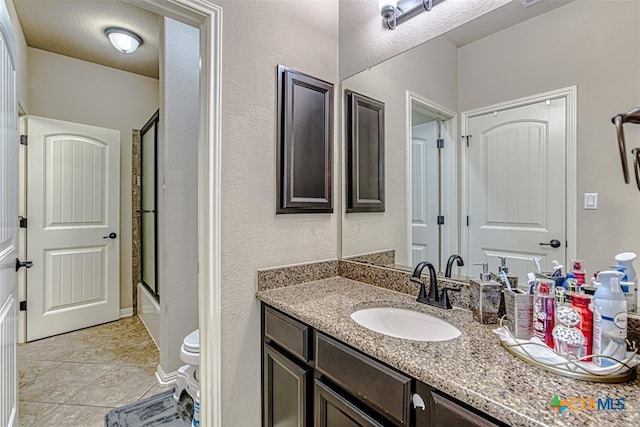 bathroom featuring toilet, vanity, and tile patterned flooring