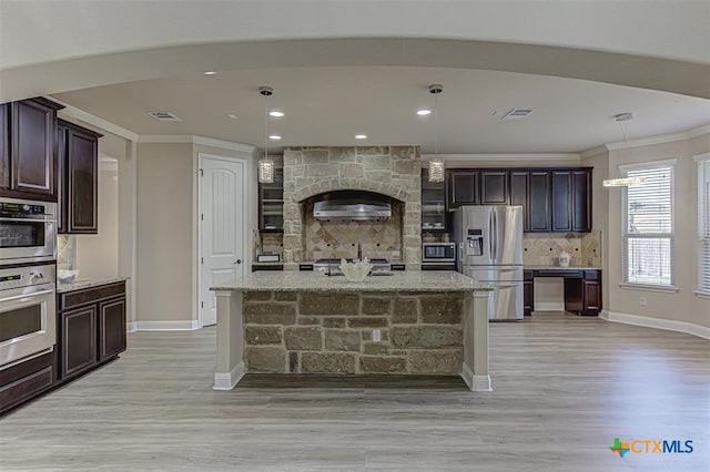 kitchen featuring tasteful backsplash, visible vents, light stone countertops, ornamental molding, and appliances with stainless steel finishes