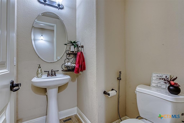 bathroom with visible vents, baseboards, and toilet