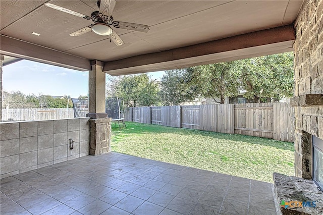 view of patio featuring a fenced backyard, ceiling fan, and a trampoline