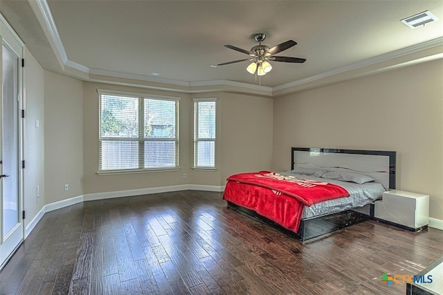 bedroom featuring visible vents, a raised ceiling, wood finished floors, and ornamental molding