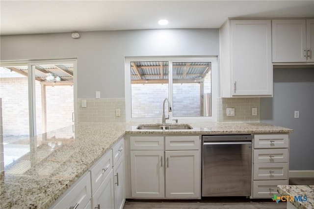 kitchen with a sink, tasteful backsplash, white cabinetry, recessed lighting, and light stone countertops