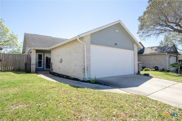 view of front of house with brick siding, a front lawn, fence, driveway, and an attached garage