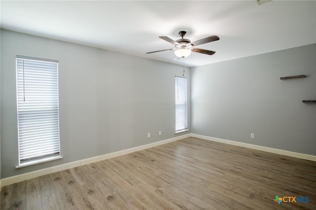 unfurnished room featuring baseboards, wood finished floors, and a ceiling fan