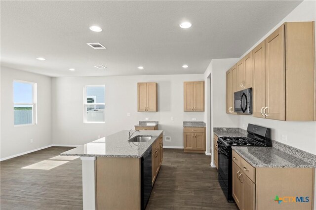 128 Bluestem Dr, Elgin, TX 78621 - kitchen featuring black appliances, a sink, light stone countertops, dark wood-type flooring, and baseboards