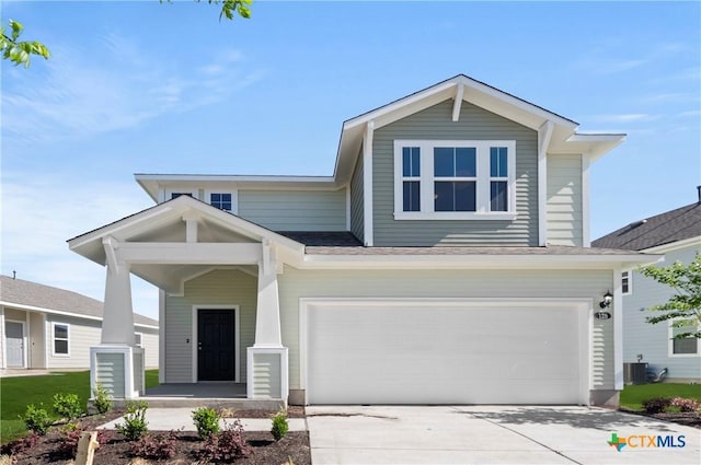 128 Bluestem Dr, Elgin, TX 78621 - view of front of home with concrete driveway, central AC, and an attached garage