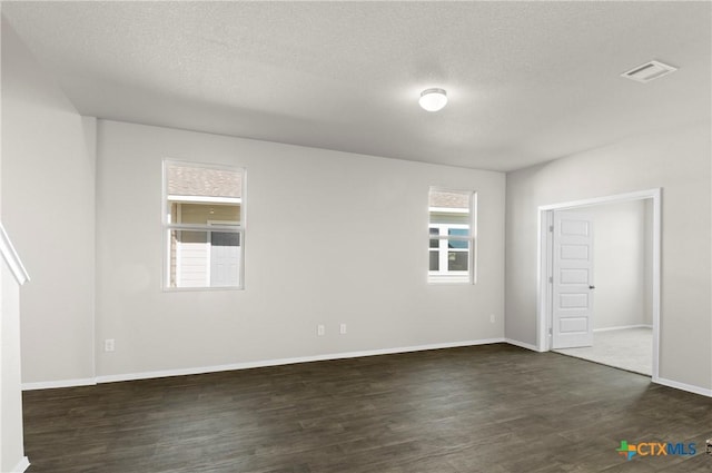 128 Bluestem Dr, Elgin, TX 78621 - unfurnished bedroom featuring dark wood finished floors, a textured ceiling, and baseboards