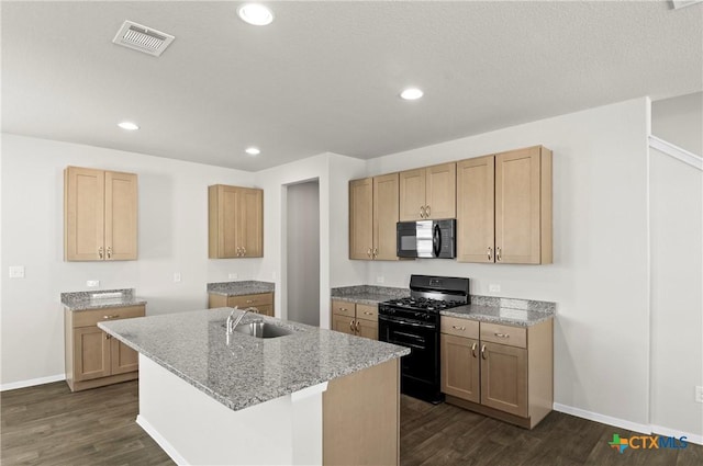 128 Bluestem Dr, Elgin, TX 78621 - kitchen with black appliances, dark wood-style flooring, a sink, a center island with sink, and recessed lighting