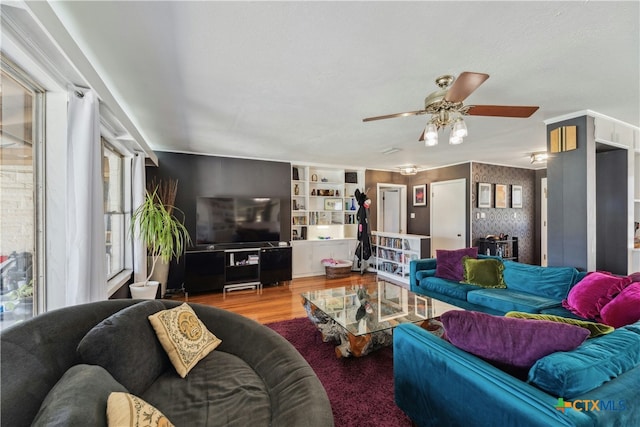 living area with a ceiling fan and wood finished floors