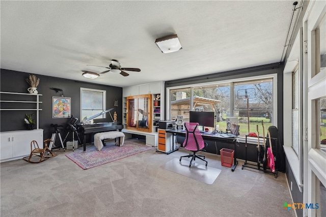 office area with carpet, ceiling fan, and a textured ceiling