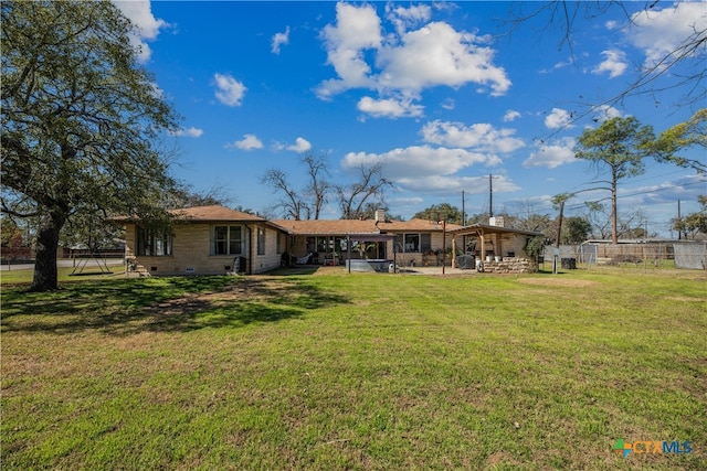 rear view of house with a yard, crawl space, a patio area, and fence