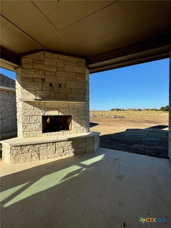 view of patio featuring an outdoor stone fireplace