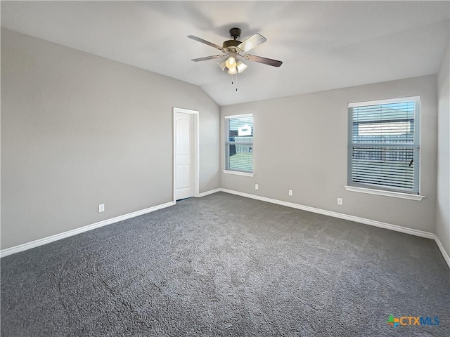 carpeted spare room featuring ceiling fan, plenty of natural light, and vaulted ceiling