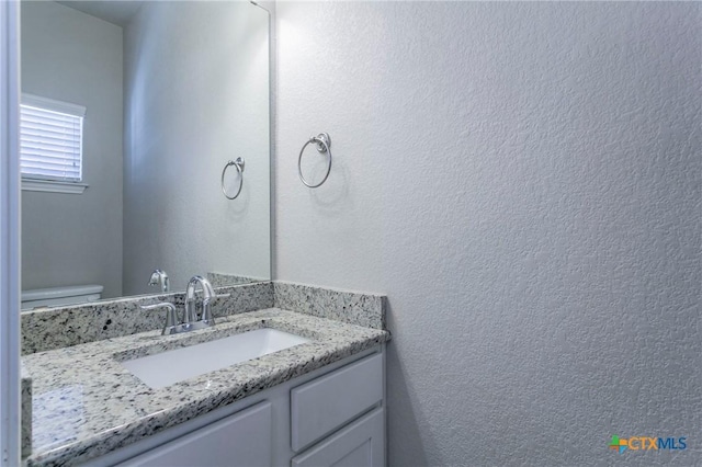 bathroom featuring vanity and toilet