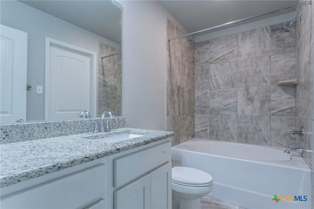 full bathroom featuring tiled shower / bath combo, toilet, and vanity