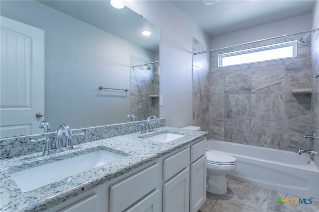 full bathroom with vanity, tiled shower / bath combo, toilet, and tile patterned flooring