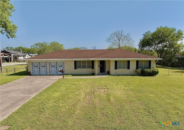 ranch-style home with brick siding, fence, a front yard, and concrete driveway