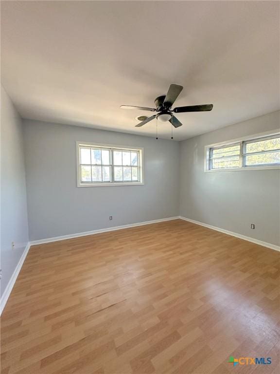 unfurnished room featuring ceiling fan, light wood-type flooring, and a wealth of natural light