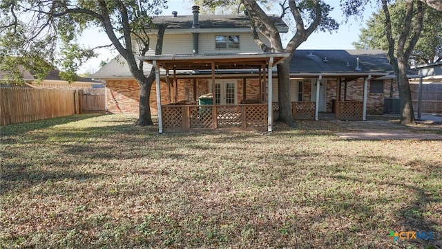 back of property featuring a lawn and french doors