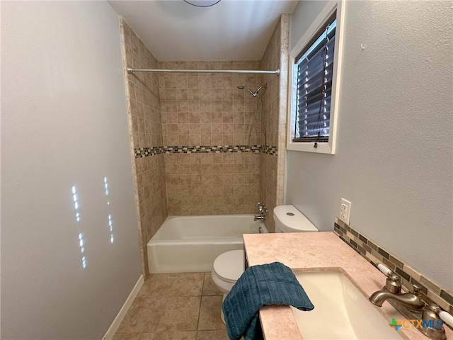 full bathroom featuring tile patterned flooring, tiled shower / bath combo, toilet, and vanity