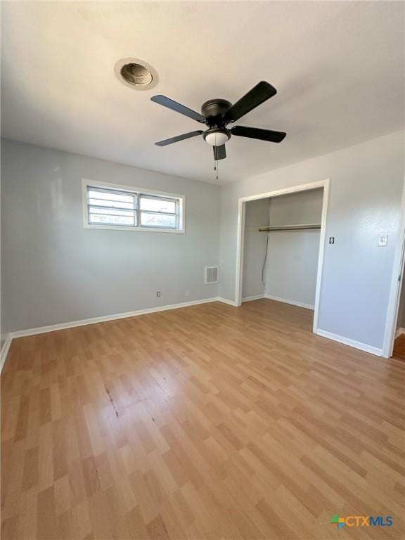 unfurnished bedroom featuring ceiling fan, light wood-type flooring, and a closet