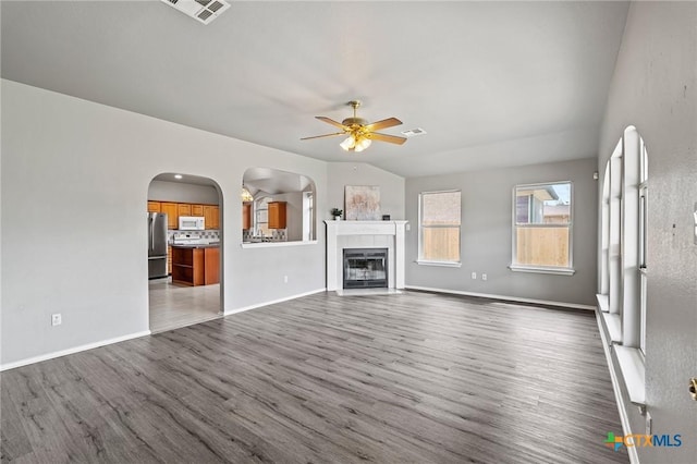 4504 Twin Oaks Cir, Killeen, TX 76542 - unfurnished living room with a ceiling fan, wood finished floors, arched walkways, and a tile fireplace
