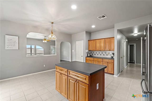 4504 Twin Oaks Cir, Killeen, TX 76542 - kitchen with arched walkways, dark countertops, a ceiling fan, decorative backsplash, and light tile patterned floors
