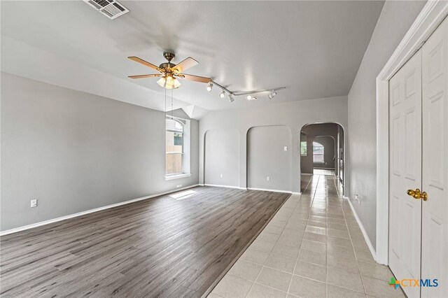 4504 Twin Oaks Cir, Killeen, TX 76542 - empty room with arched walkways, ceiling fan, rail lighting, light wood-style floors, and vaulted ceiling