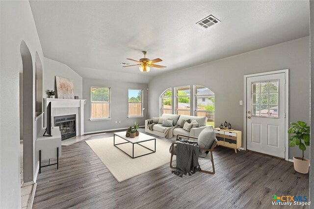 4504 Twin Oaks Cir, Killeen, TX 76542 - living area with a ceiling fan, wood finished floors, arched walkways, and a glass covered fireplace