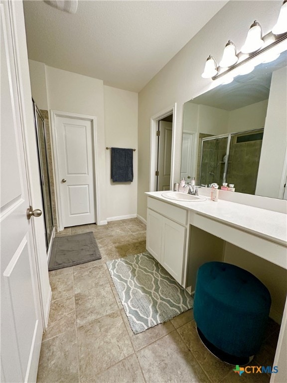 bathroom with vanity, tile patterned flooring, and a shower with door