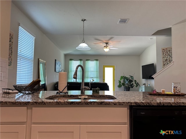 kitchen with stone countertops, white cabinetry, sink, and black dishwasher