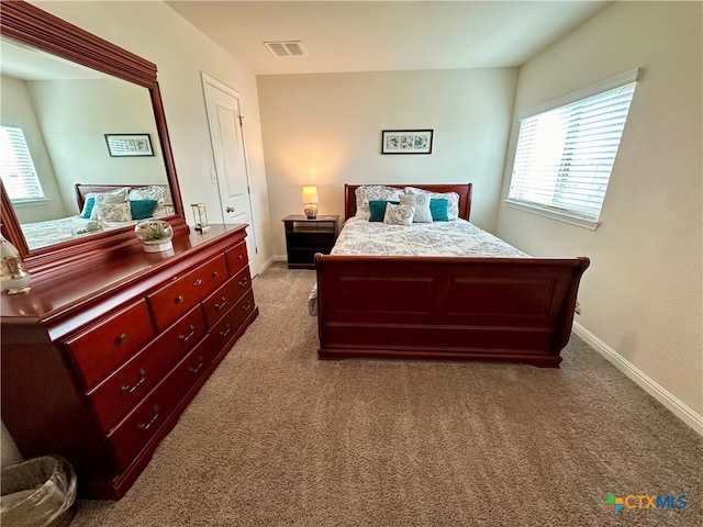 bedroom featuring multiple windows and light carpet