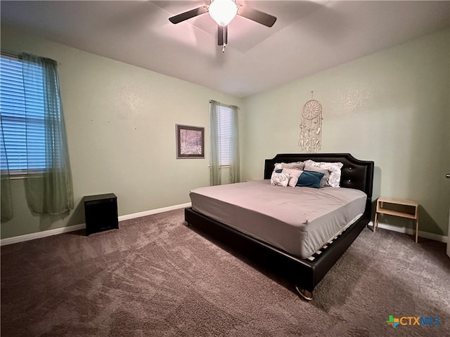 bedroom with multiple windows, ceiling fan, and dark colored carpet