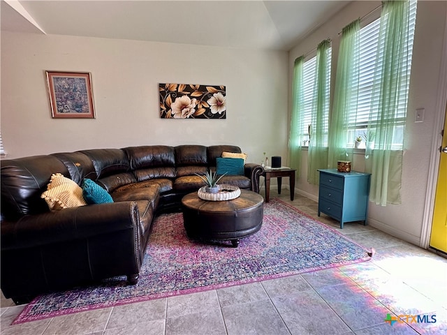 living room with light tile patterned floors and lofted ceiling