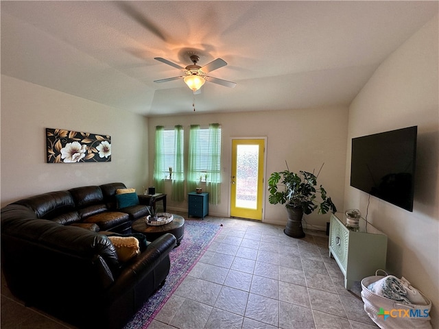 living room featuring lofted ceiling, ceiling fan, and light tile patterned floors