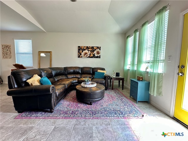 living room with light tile patterned floors and lofted ceiling