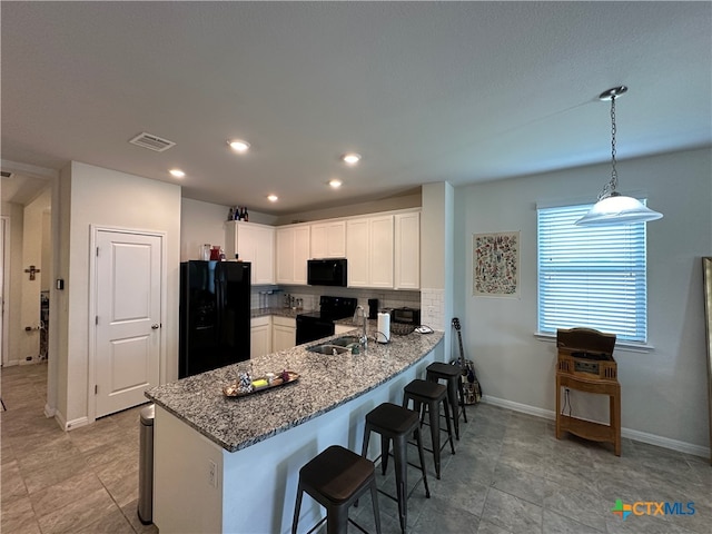 kitchen with kitchen peninsula, decorative backsplash, black appliances, white cabinetry, and decorative light fixtures