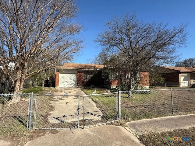 ranch-style house with a fenced front yard, brick siding, concrete driveway, an attached garage, and a gate