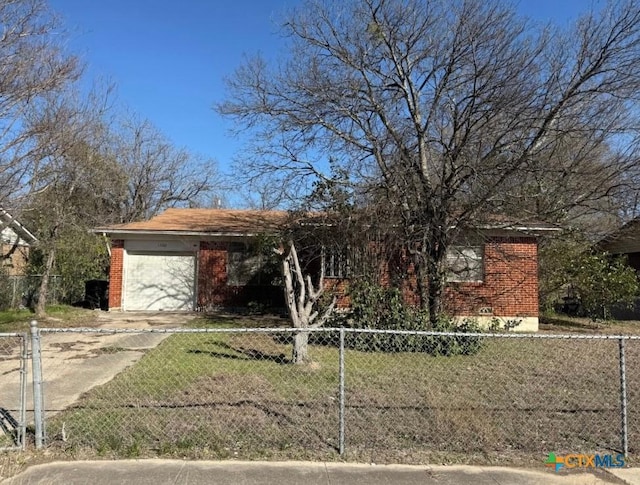 view of front of property with a fenced front yard, concrete driveway, brick siding, and a garage